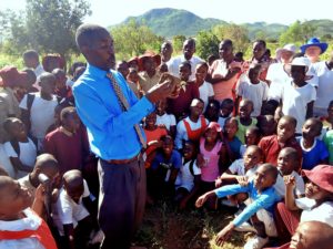 Das Foto zeigt den Schulleiter der Sacred Heart Primary School in Manicaland, Simbabwe, wie er mit seinen Schülern einen Baum pflanzt.